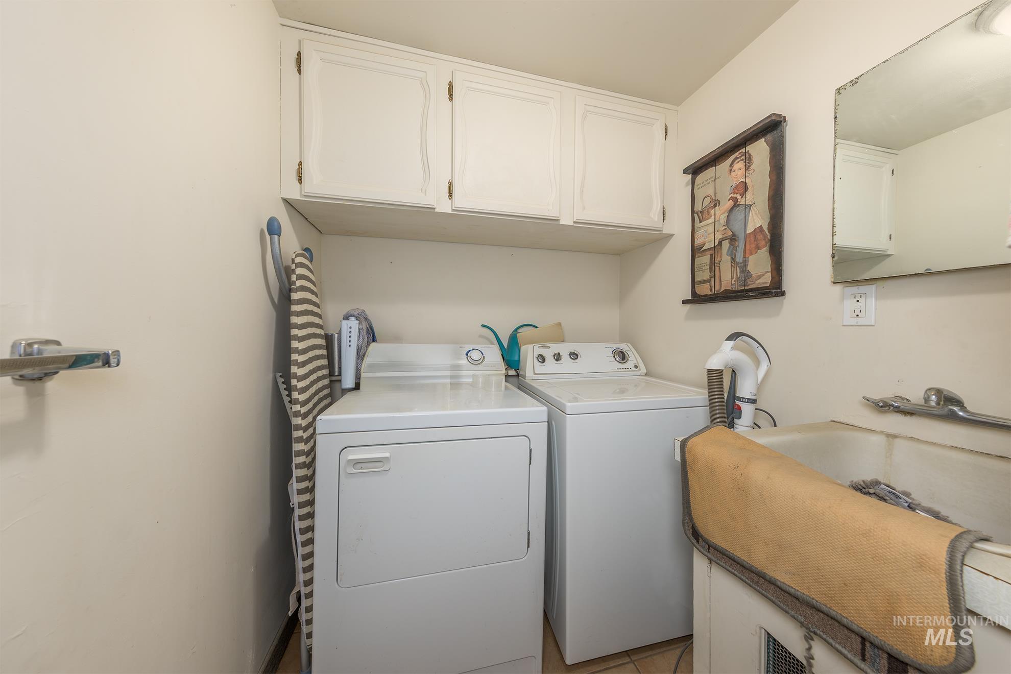 Washroom featuring cabinet space and separate washer and dryer