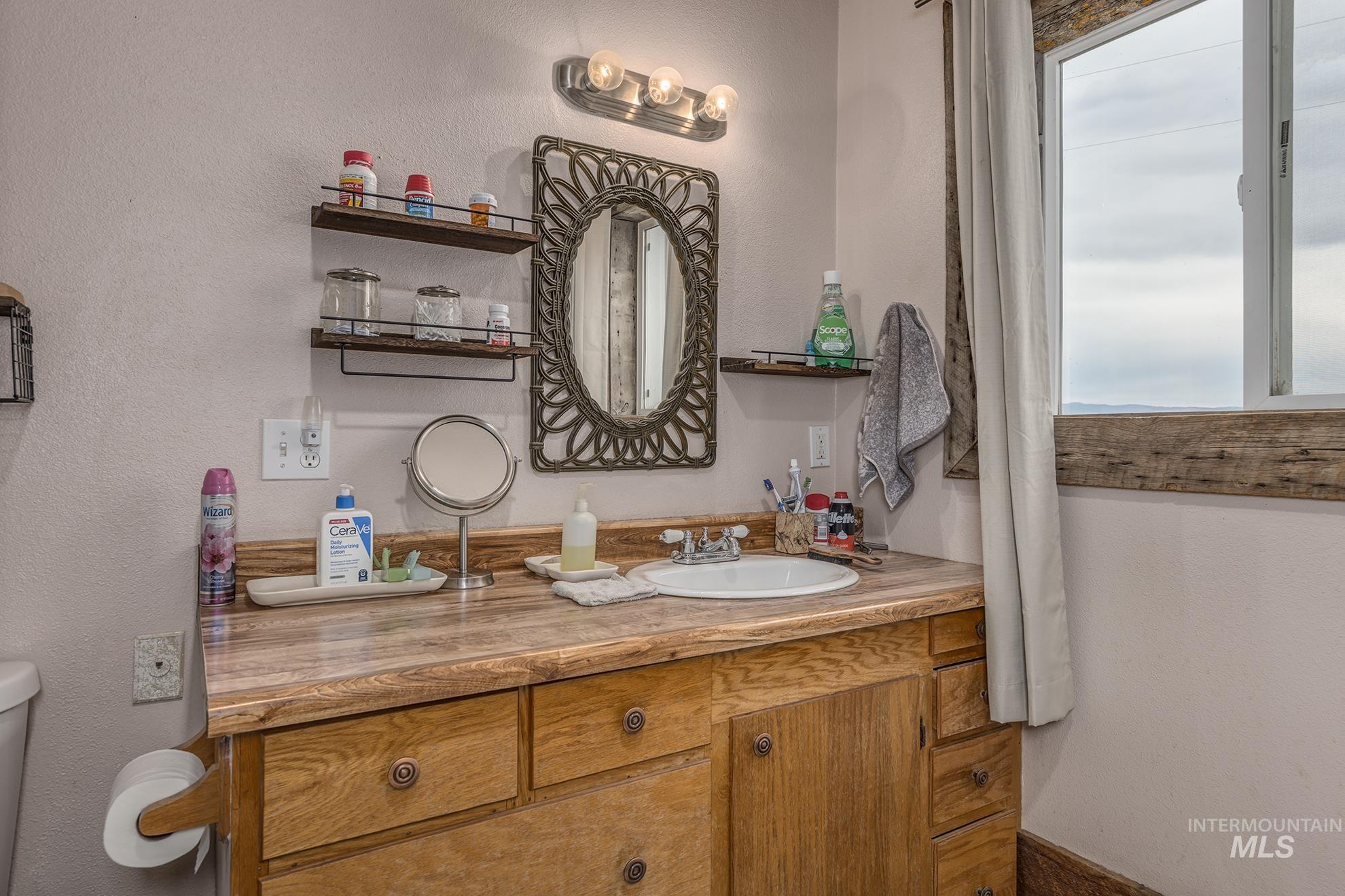 Bathroom featuring a textured wall and vanity