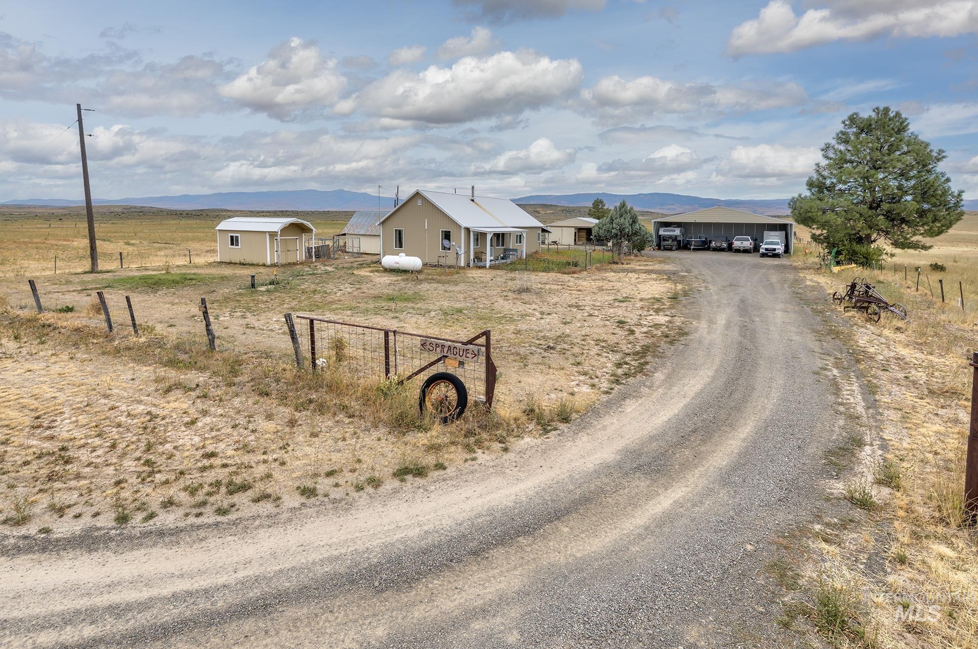 View of dirt / gravel road with a rural view and a mountain view
