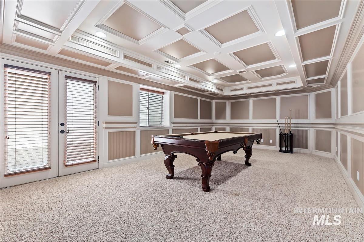 Game room featuring billiards table, coffered ceiling, light carpet, a decorative wall, and ornamental molding