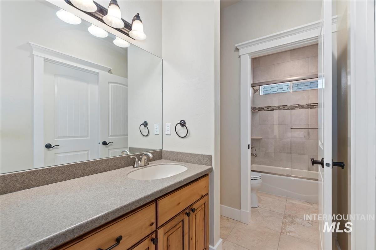 Bathroom with vanity, bathtub / shower combination, and light tile patterned floors