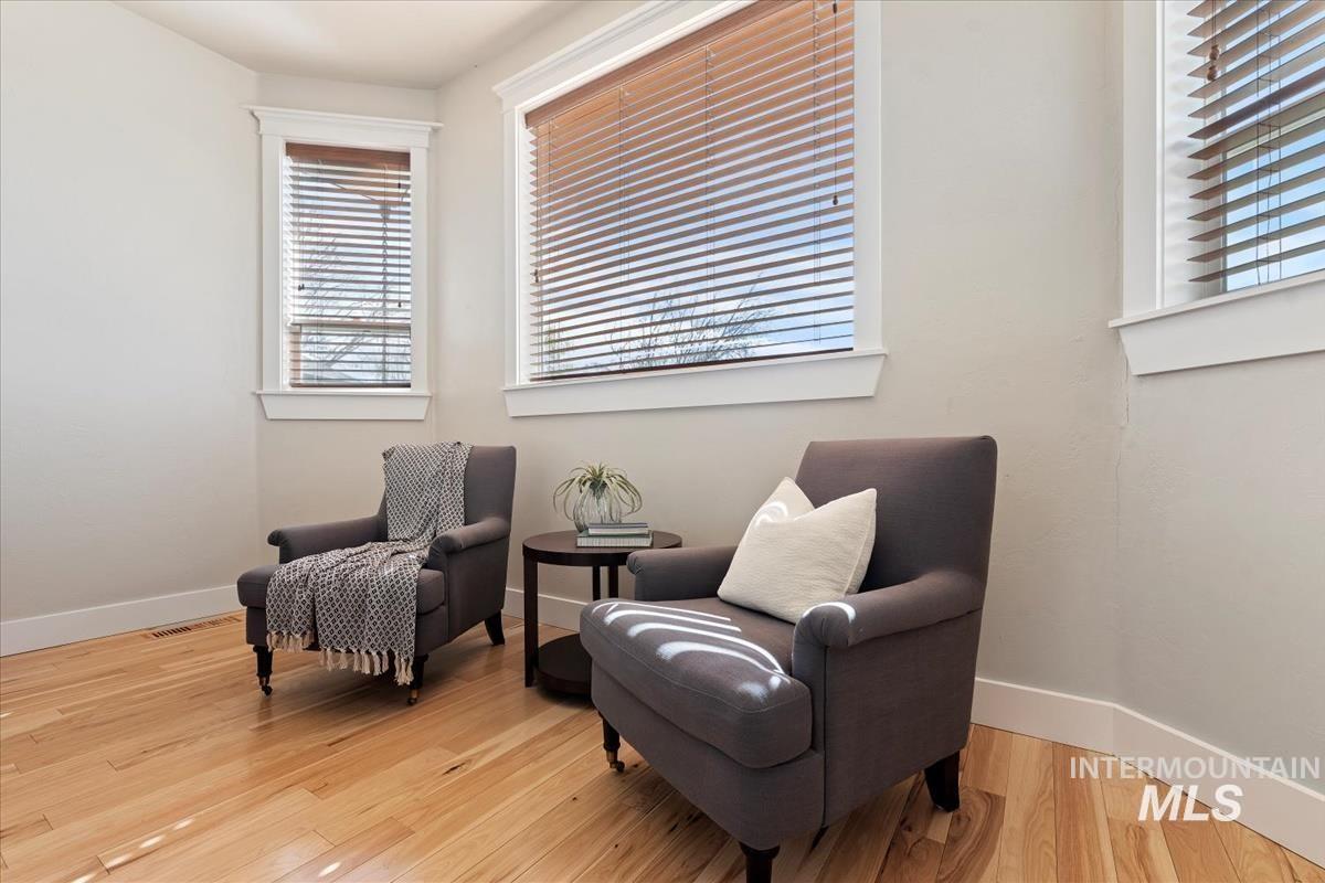 Living area with light wood-style flooring and healthy amount of natural light
