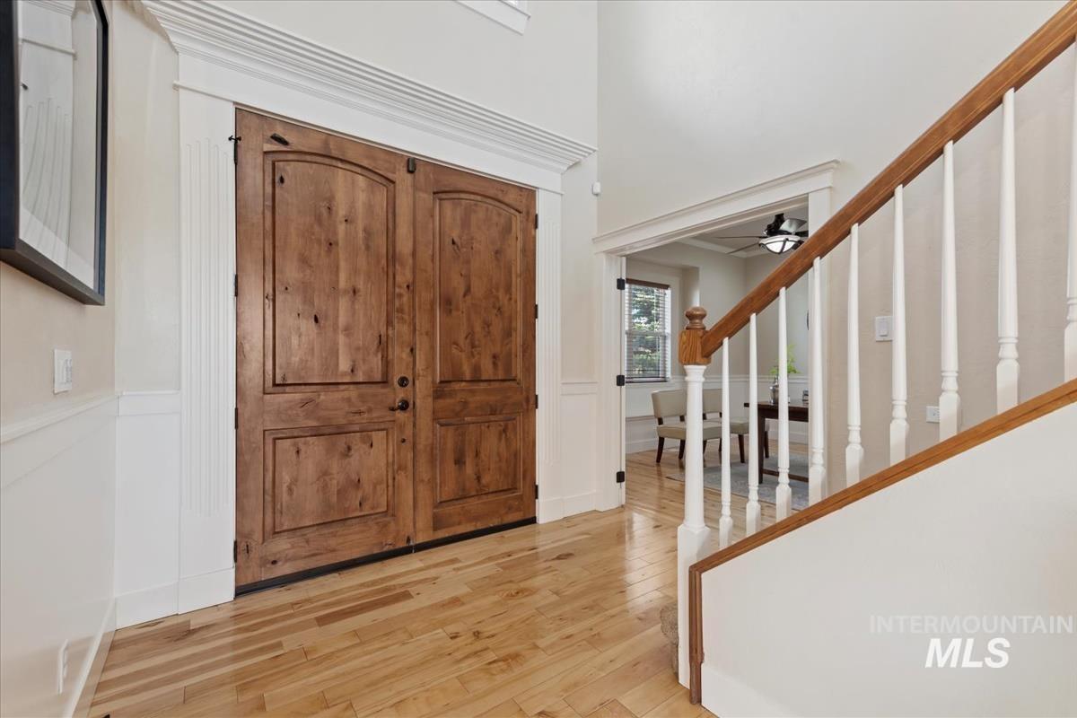 Entrance foyer with stairway, wood finished floors, and ceiling fan