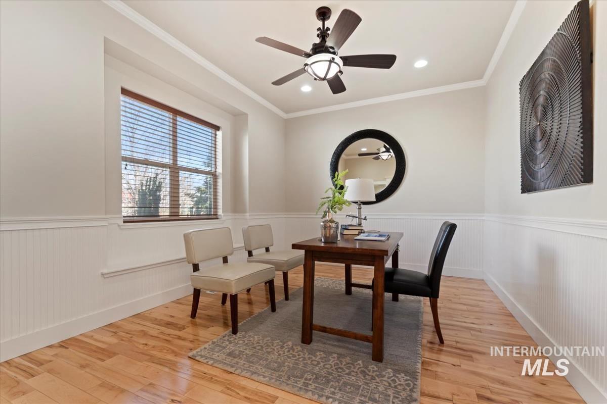 Sitting room with a wainscoted wall, ceiling fan, light wood-type flooring, ornamental molding, and recessed lighting
