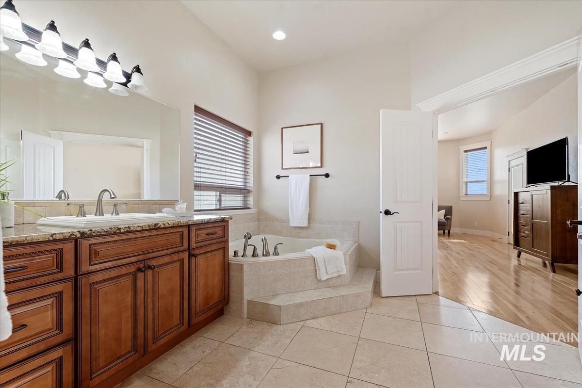 Bathroom with vanity, a garden tub, light tile patterned floors, and recessed lighting