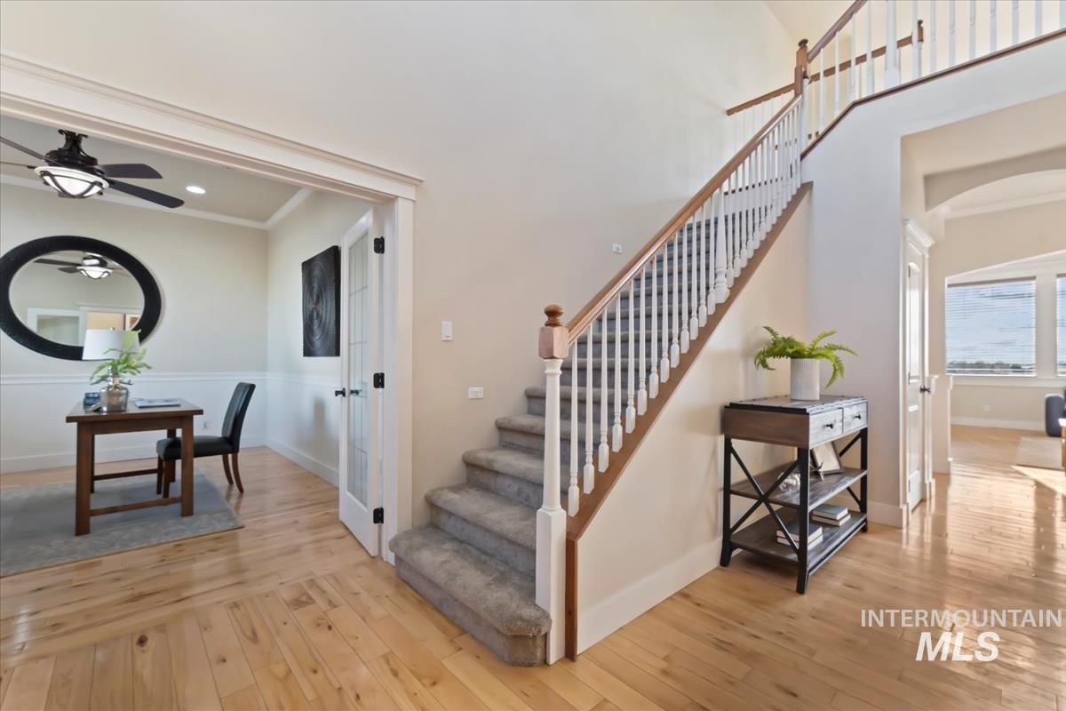 Stairs featuring hardwood / wood-style flooring, arched walkways, ceiling fan, ornamental molding, and recessed lighting