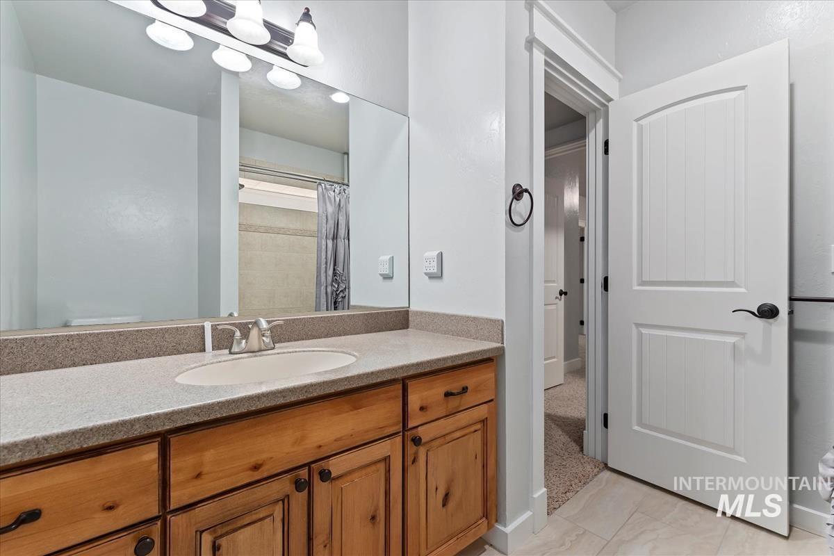 Bathroom with vanity, curtained shower, and light tile patterned floors