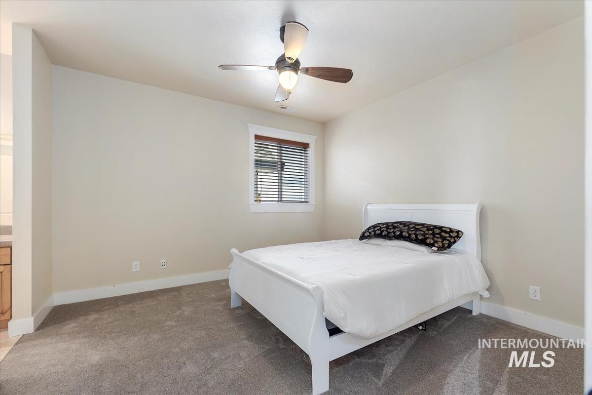 Bedroom featuring light colored carpet and ceiling fan