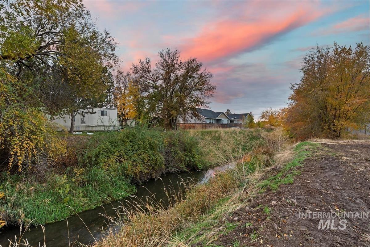Yard at dusk featuring a water view