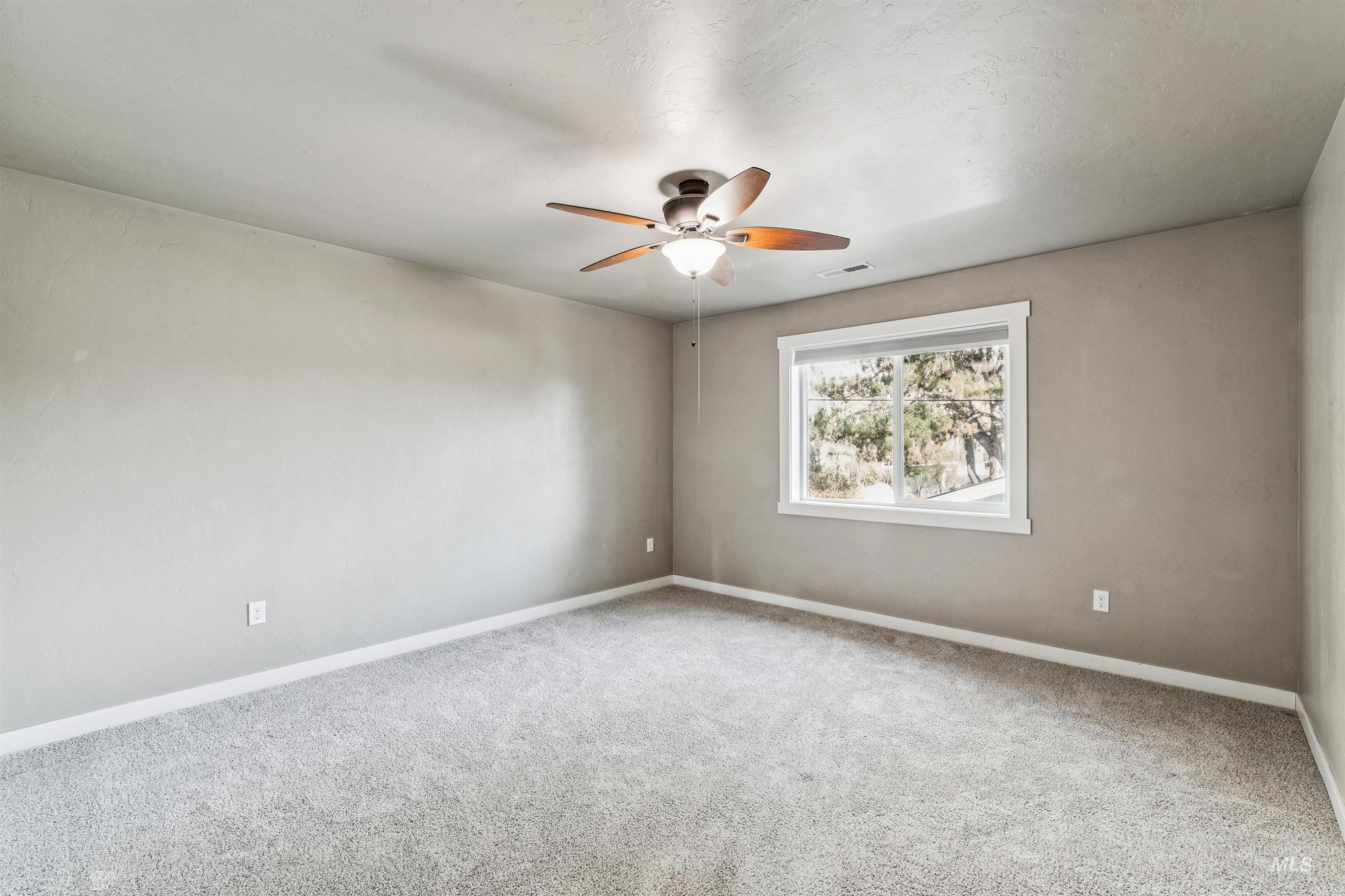 Empty room featuring carpet flooring and ceiling fan