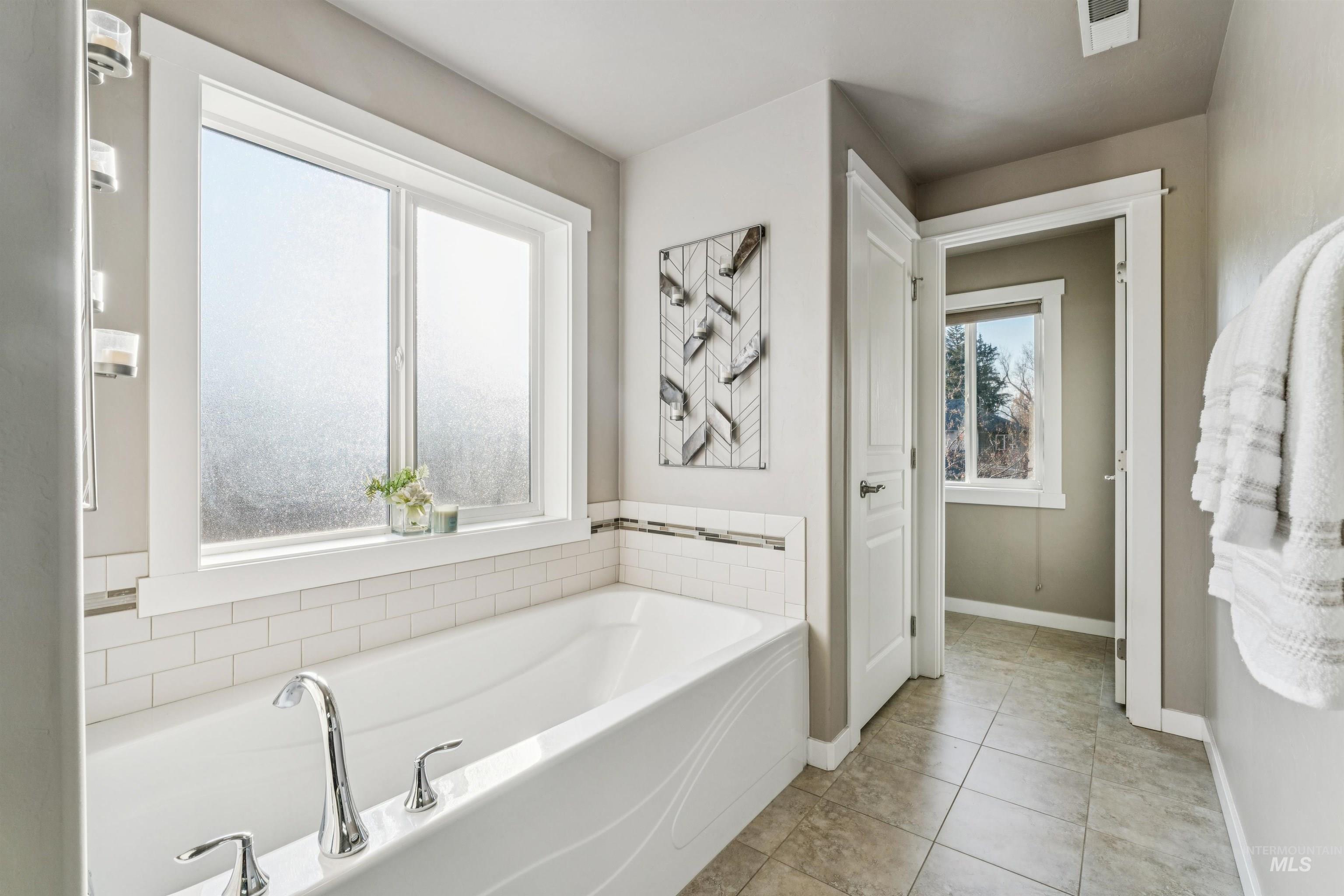Bathroom featuring a garden tub and light tile patterned floors