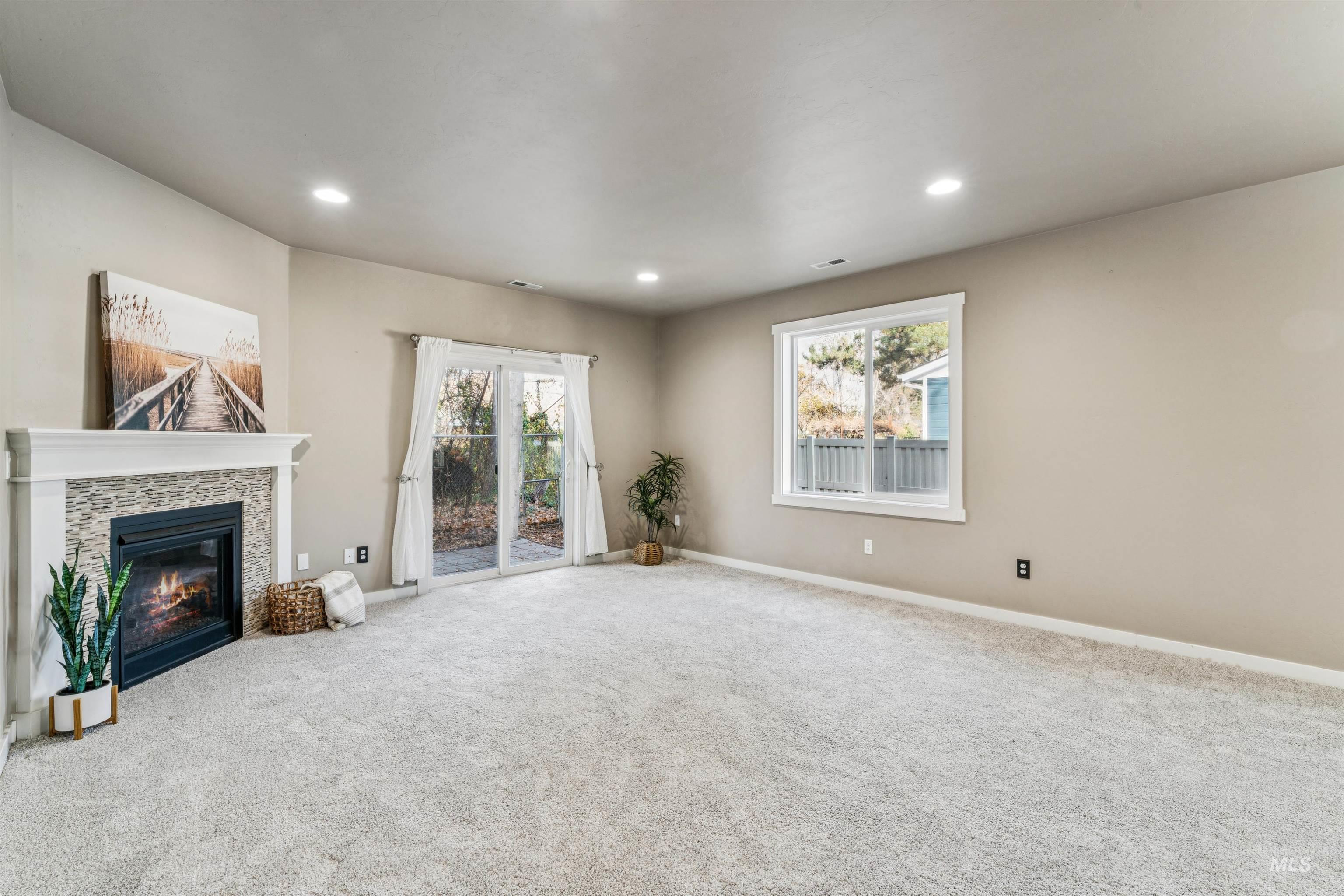Unfurnished living room featuring carpet, recessed lighting, and a tile fireplace