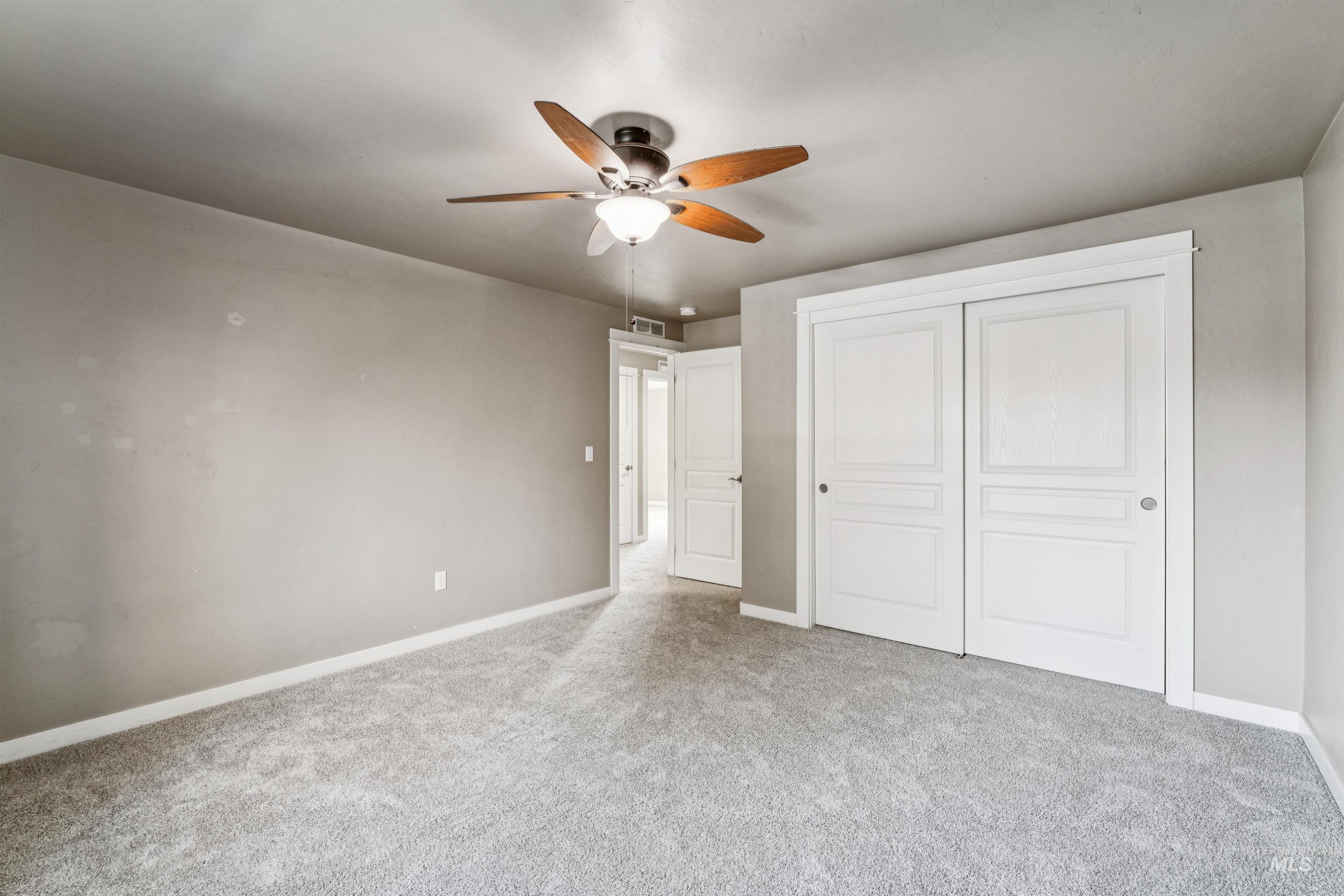 Unfurnished bedroom featuring a closet, carpet floors, and ceiling fan