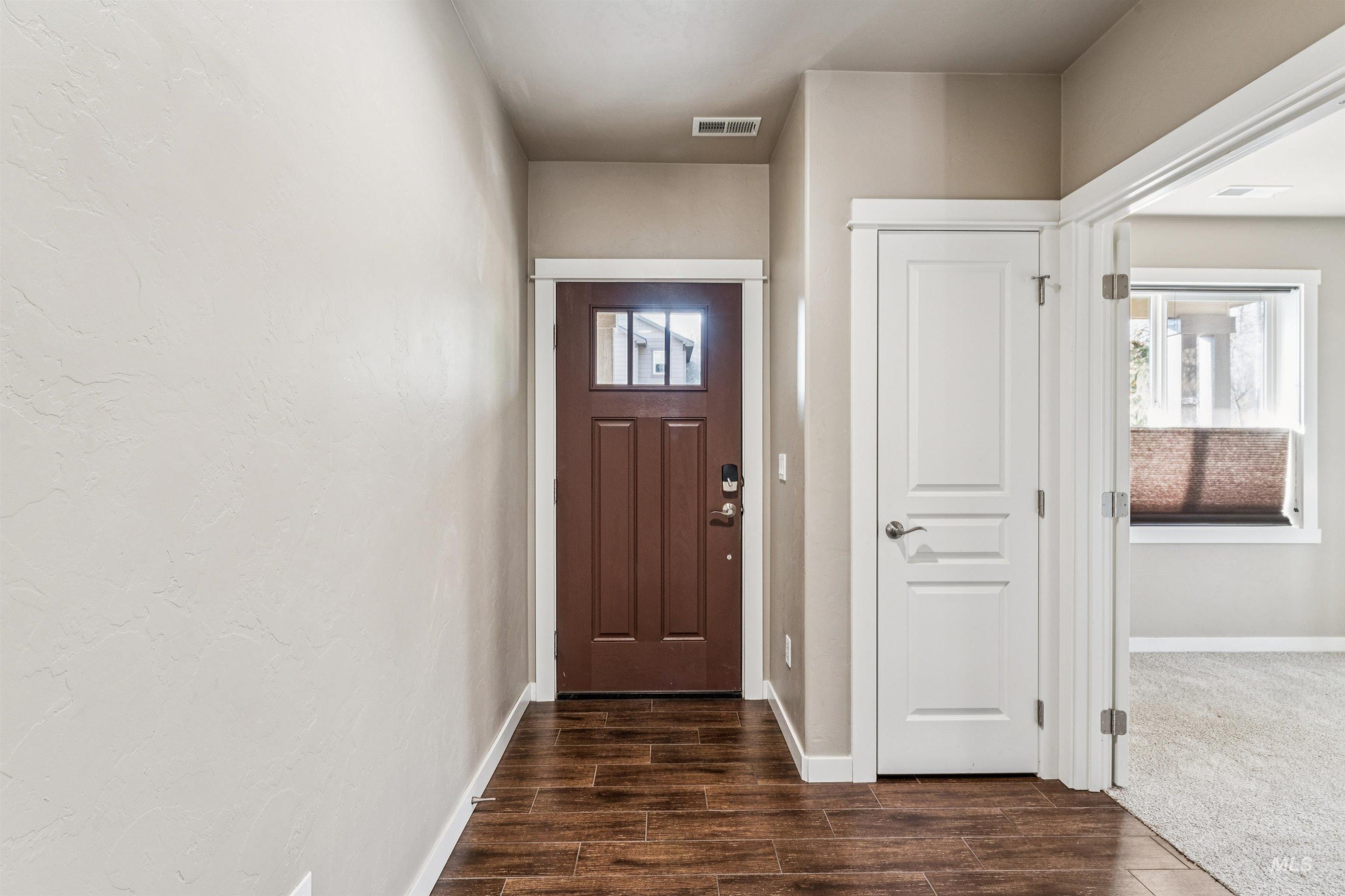 Entrance foyer featuring baseboards and dark wood-type flooring