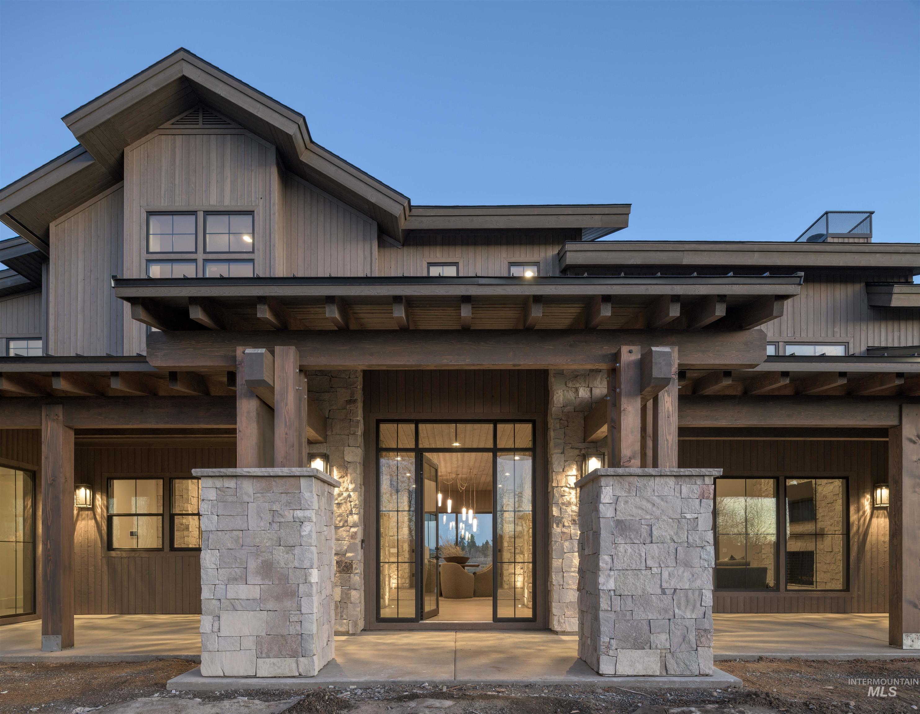 Doorway to property featuring stone siding and a porch - finished driveway