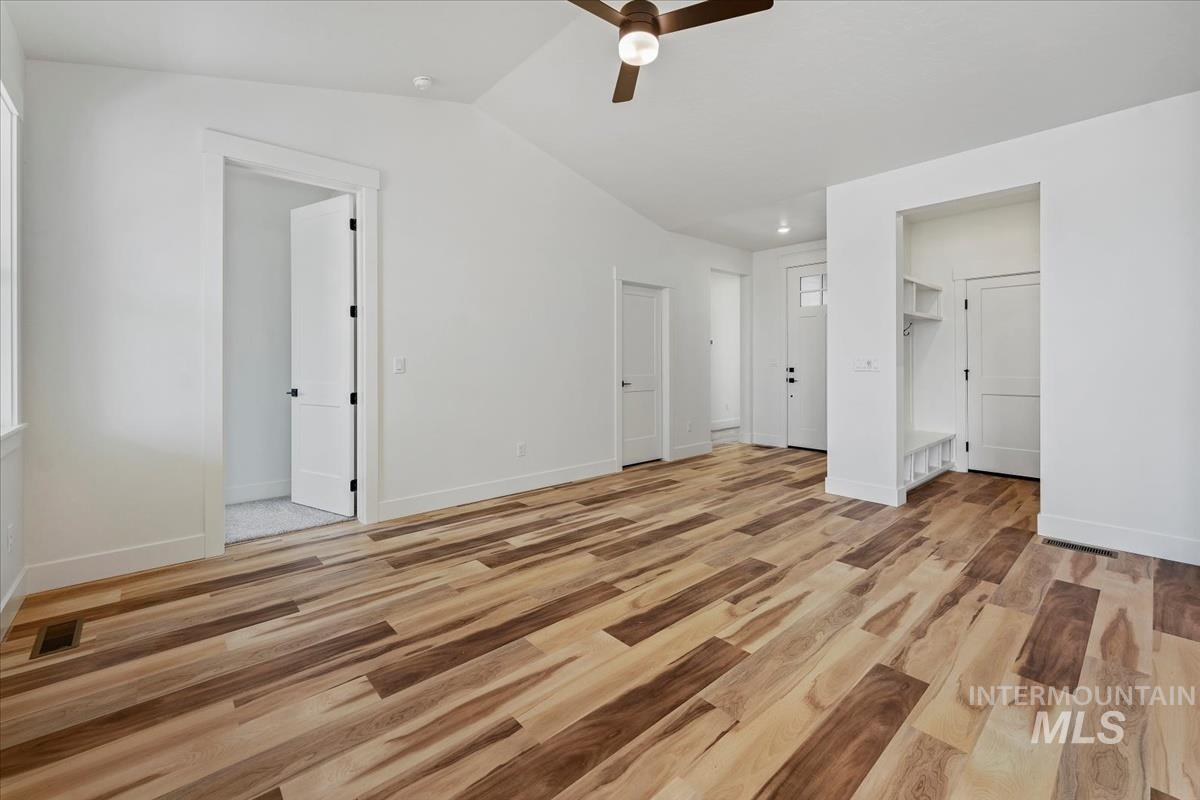 Unfurnished bedroom featuring light wood-type flooring, vaulted ceiling, and ceiling fan