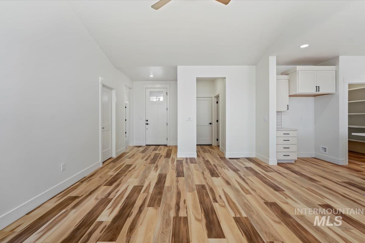 Unfurnished bedroom featuring light wood finished floors, recessed lighting, a walk in closet, and ceiling fan