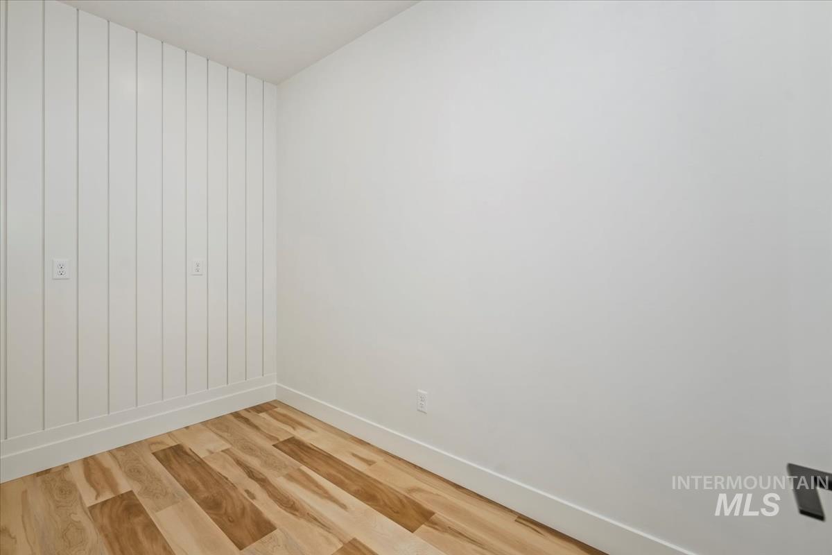 Spare room featuring light wood-style floors and baseboards
