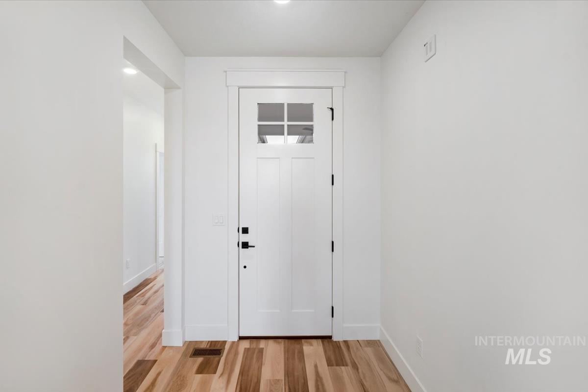 Doorway with light wood-style floors and baseboards