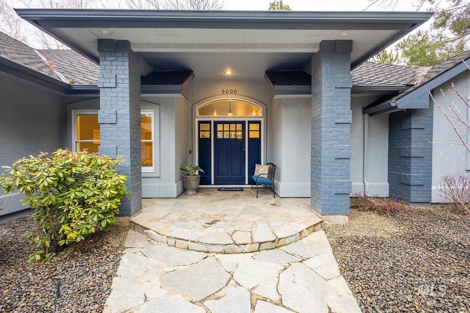 Property entrance featuring stucco siding, a porch, and a shingled roof