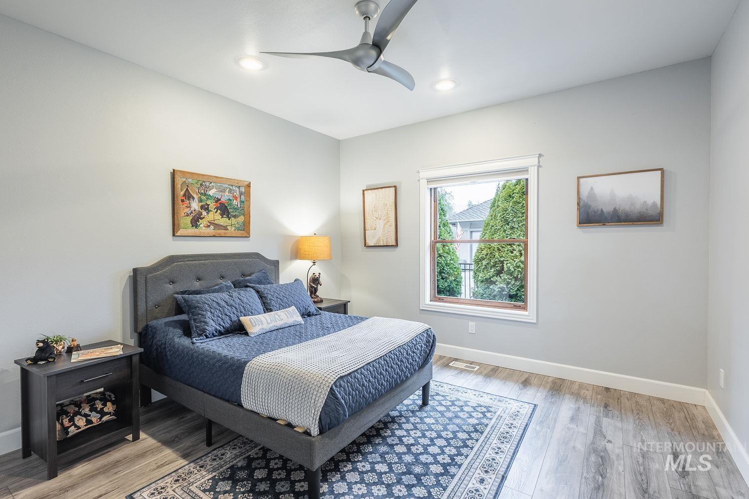 Bedroom featuring light wood-style flooring, ceiling fan, and recessed lighting