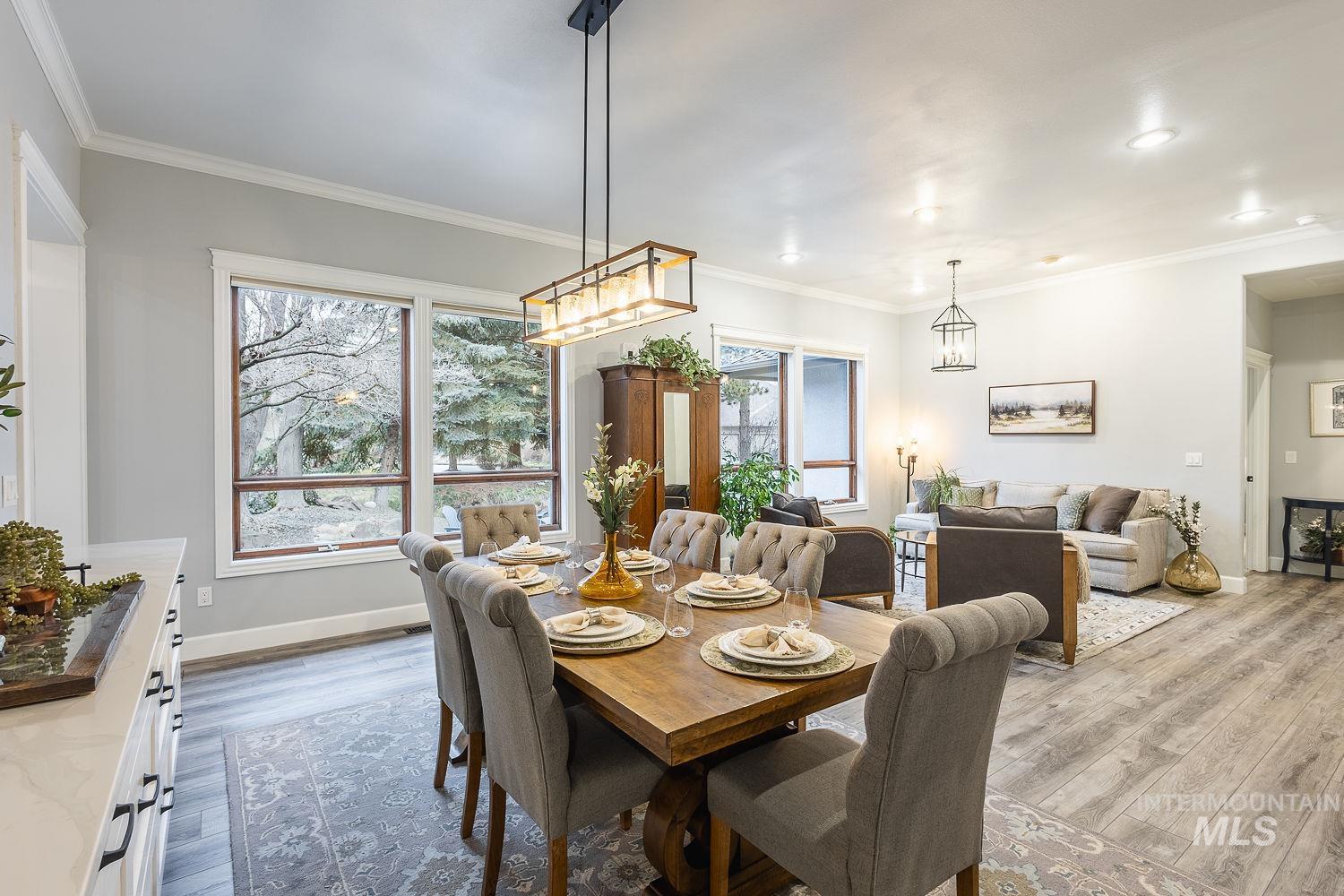 Dining area with wood finished floors and crown molding
