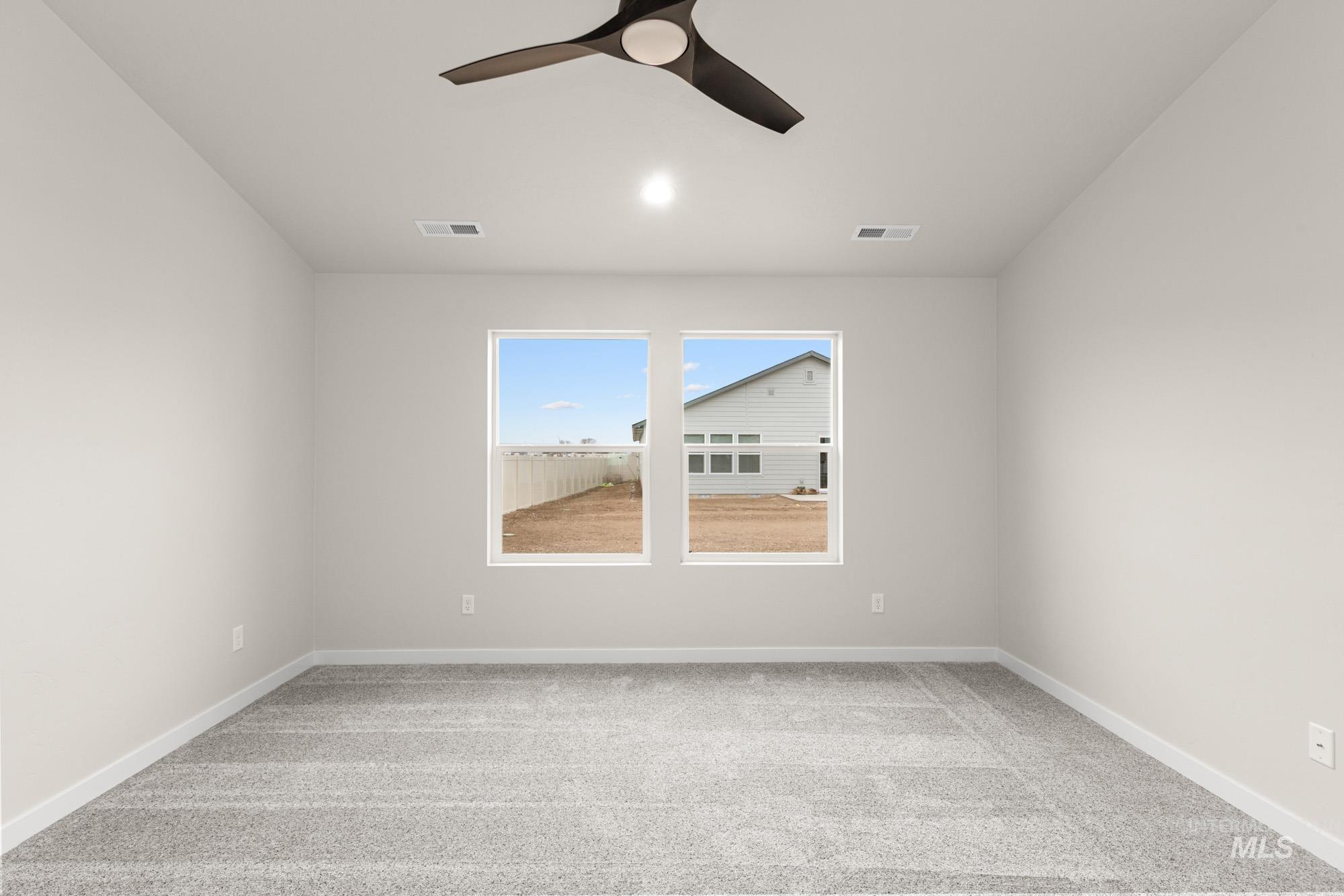 Spare room with light carpet and a ceiling fan