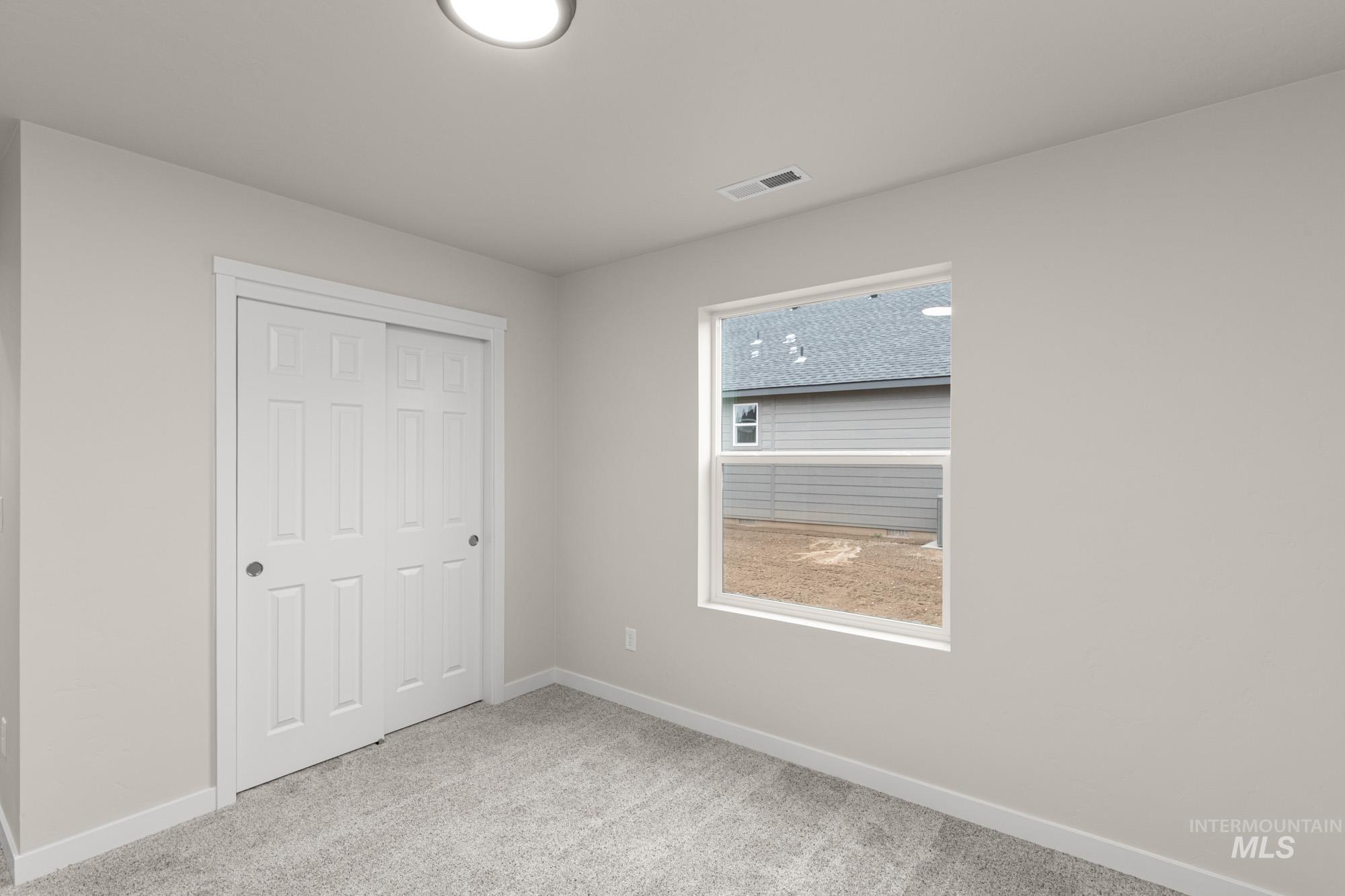 Unfurnished bedroom with light colored carpet and a closet
