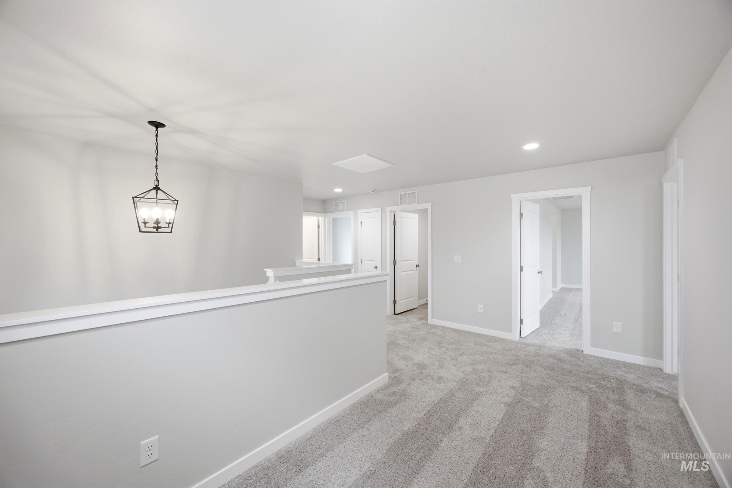 Upper level landing with gray carpet flooring and white trim