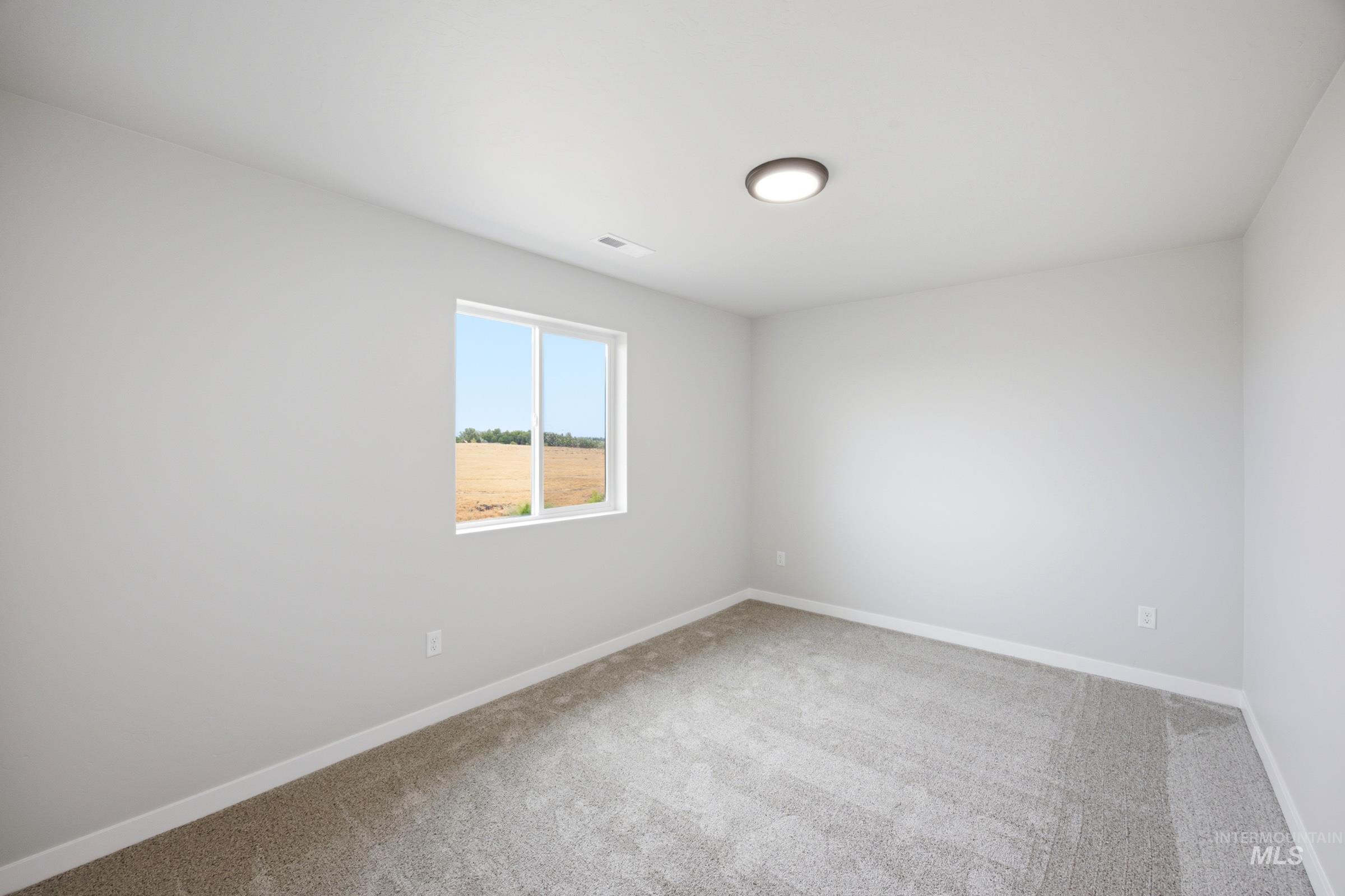 Light-filled room featuring a single window, recessed ceiling light, wall-to-wall carpeting, and white baseboards