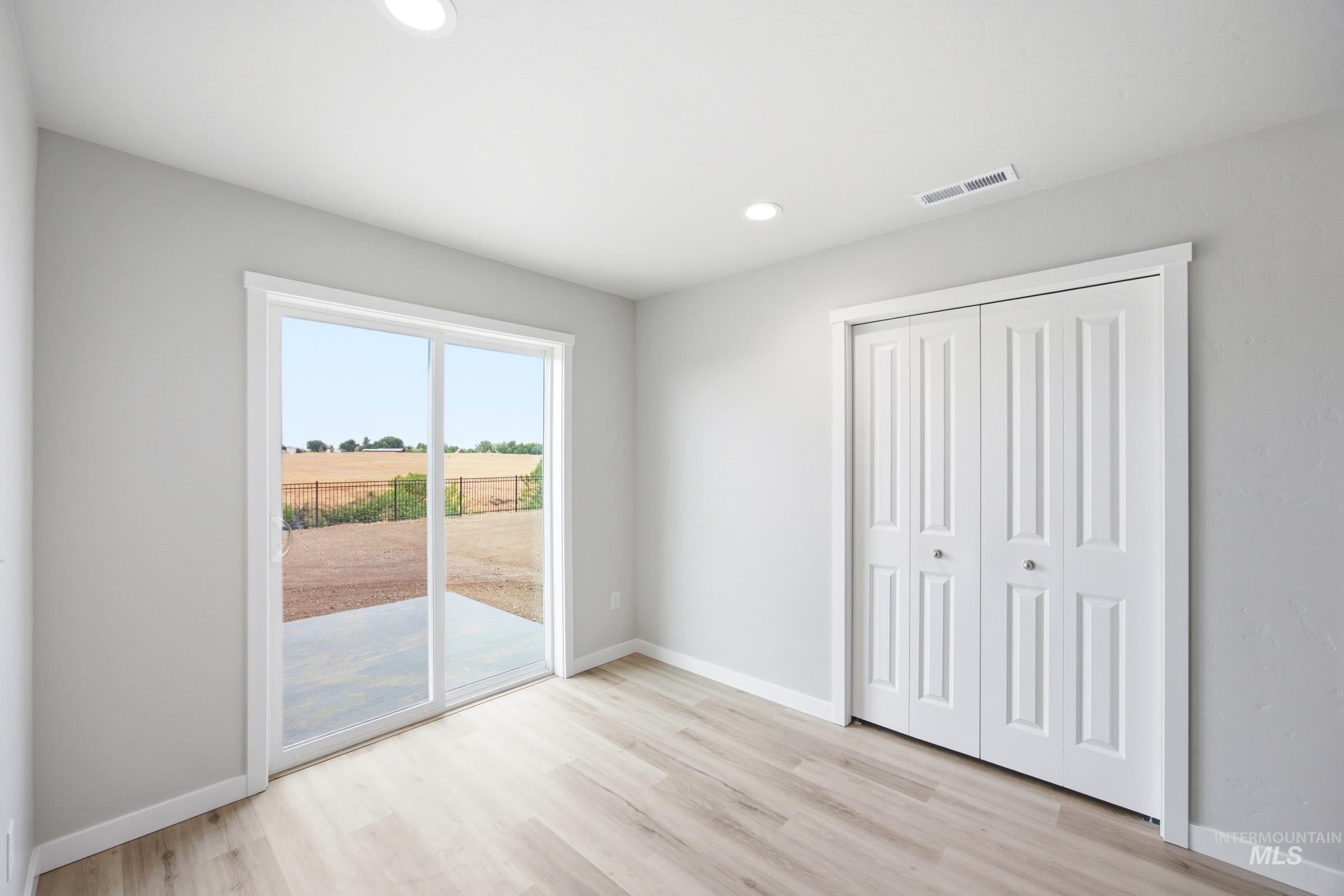 Room featuring light wood-finish flooring and light gray walls