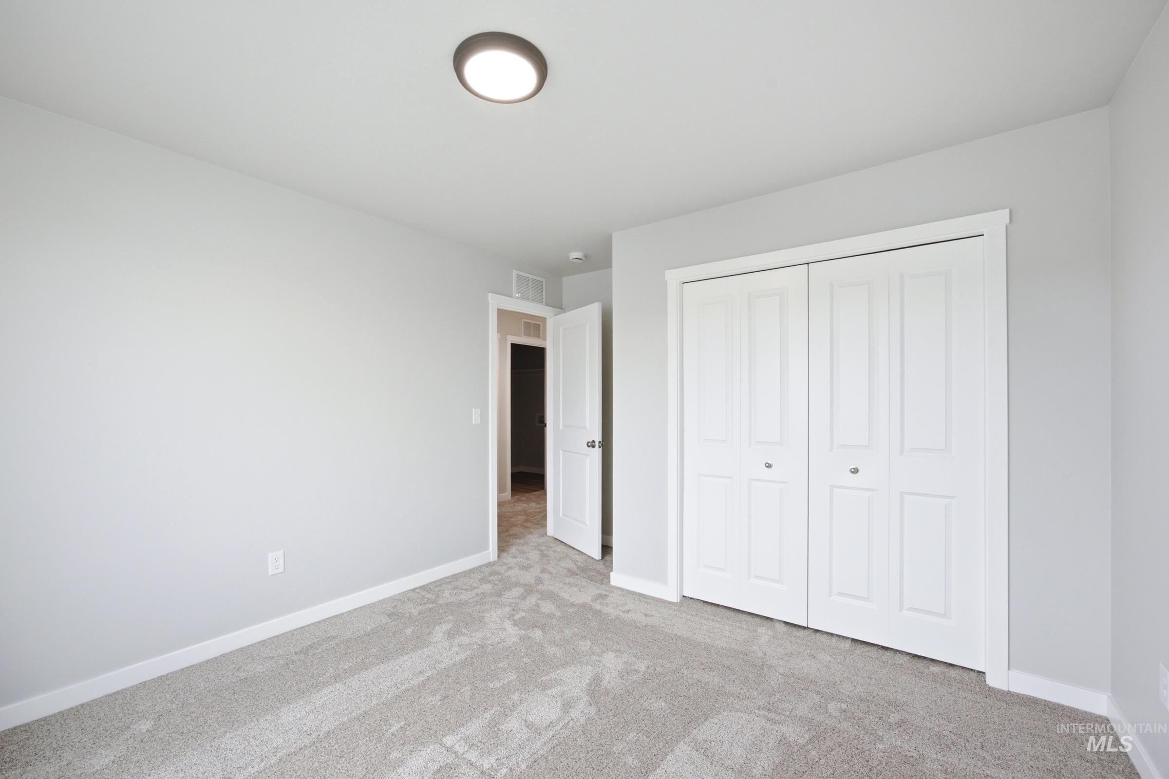 Light gray wall tones with white trim and a neutral carpet