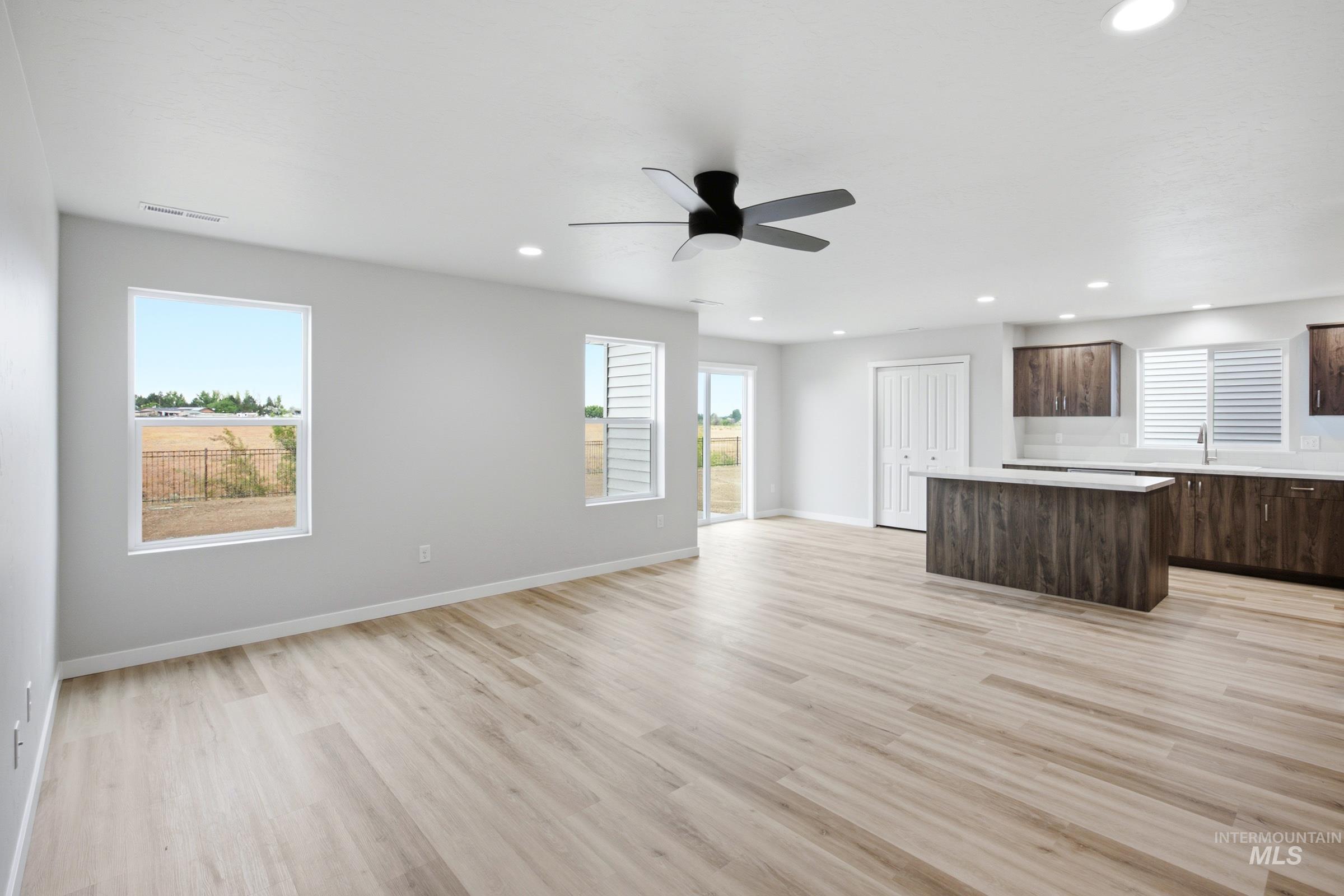Open-concept living space featuring wood-finish flooring and recessed lighting