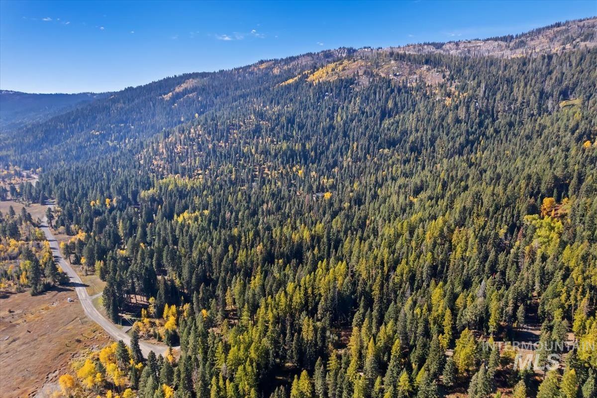 Aerial view of property and surrounding area with a mountain backdrop
