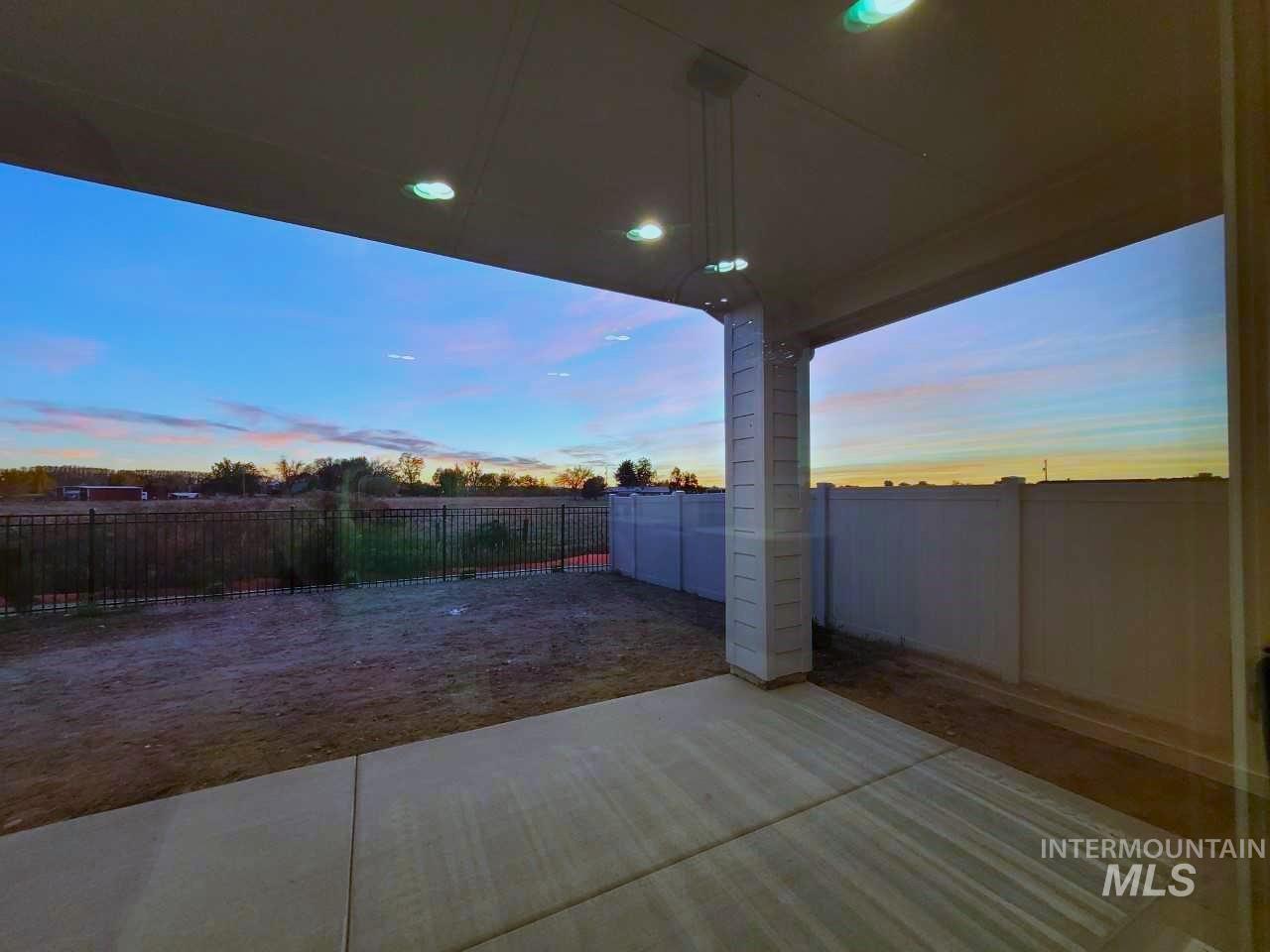 Patio terrace at dusk featuring a patio area and a fenced backyard