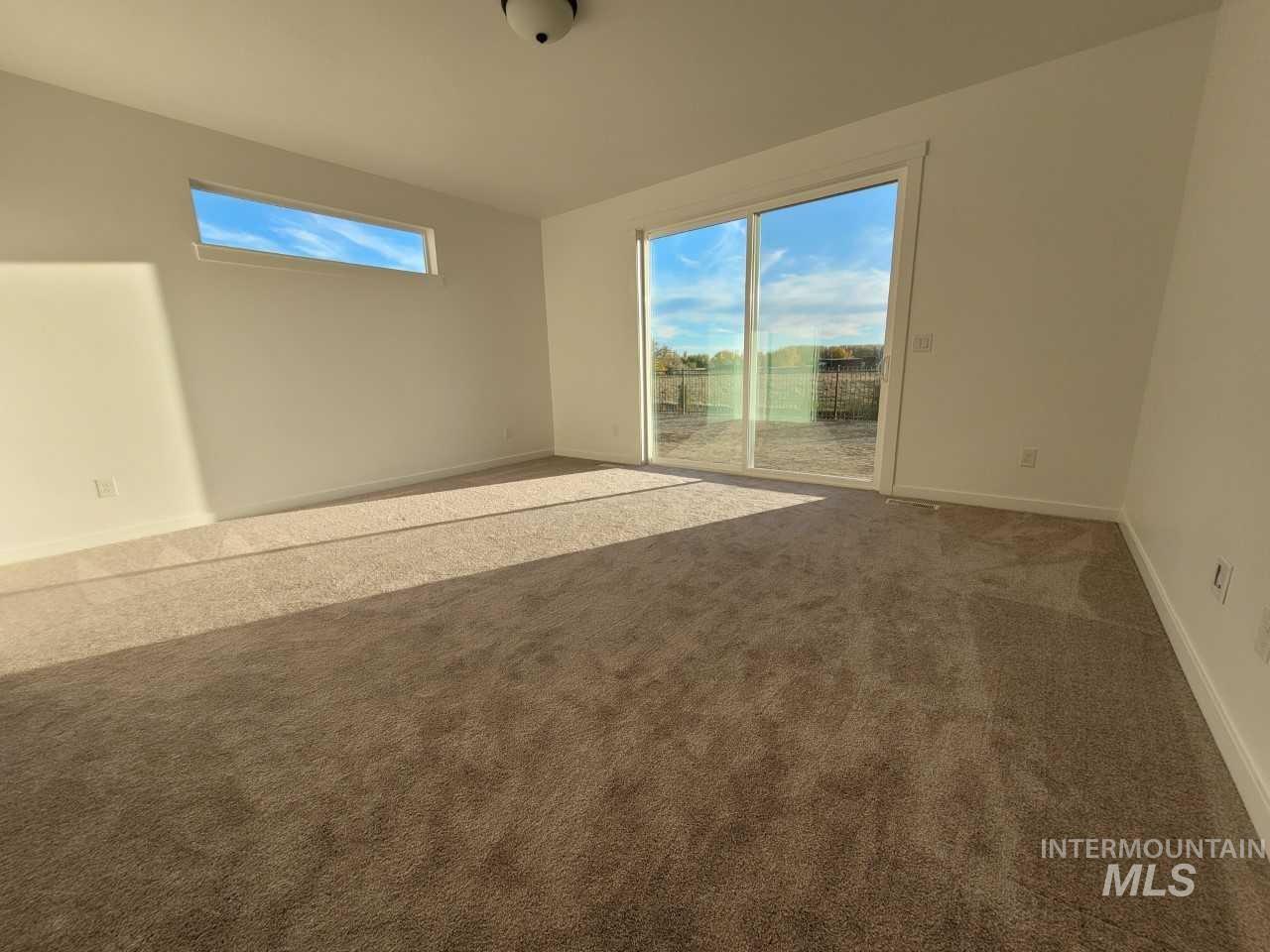 Empty room featuring carpet and baseboards