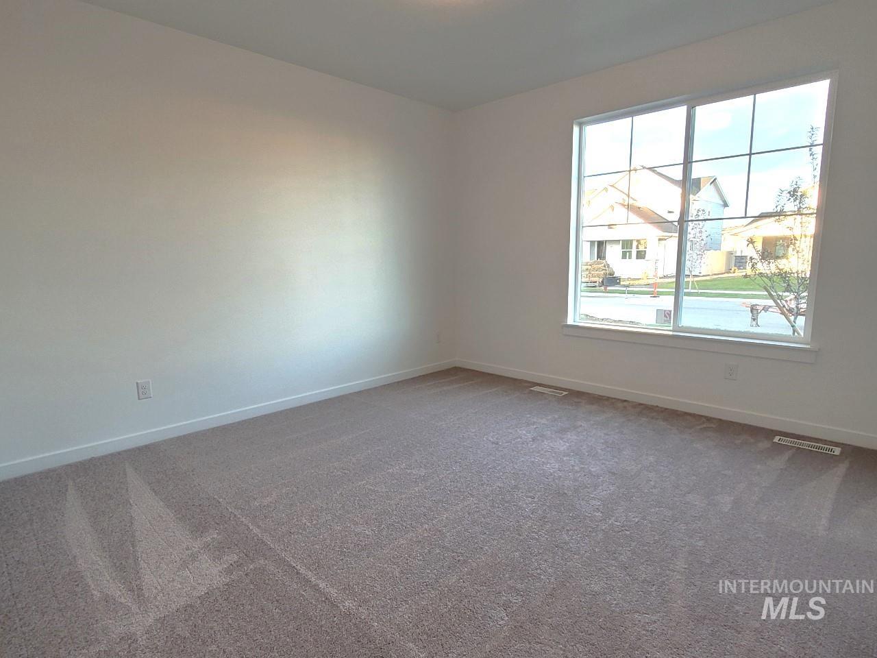 Carpeted empty room with baseboards