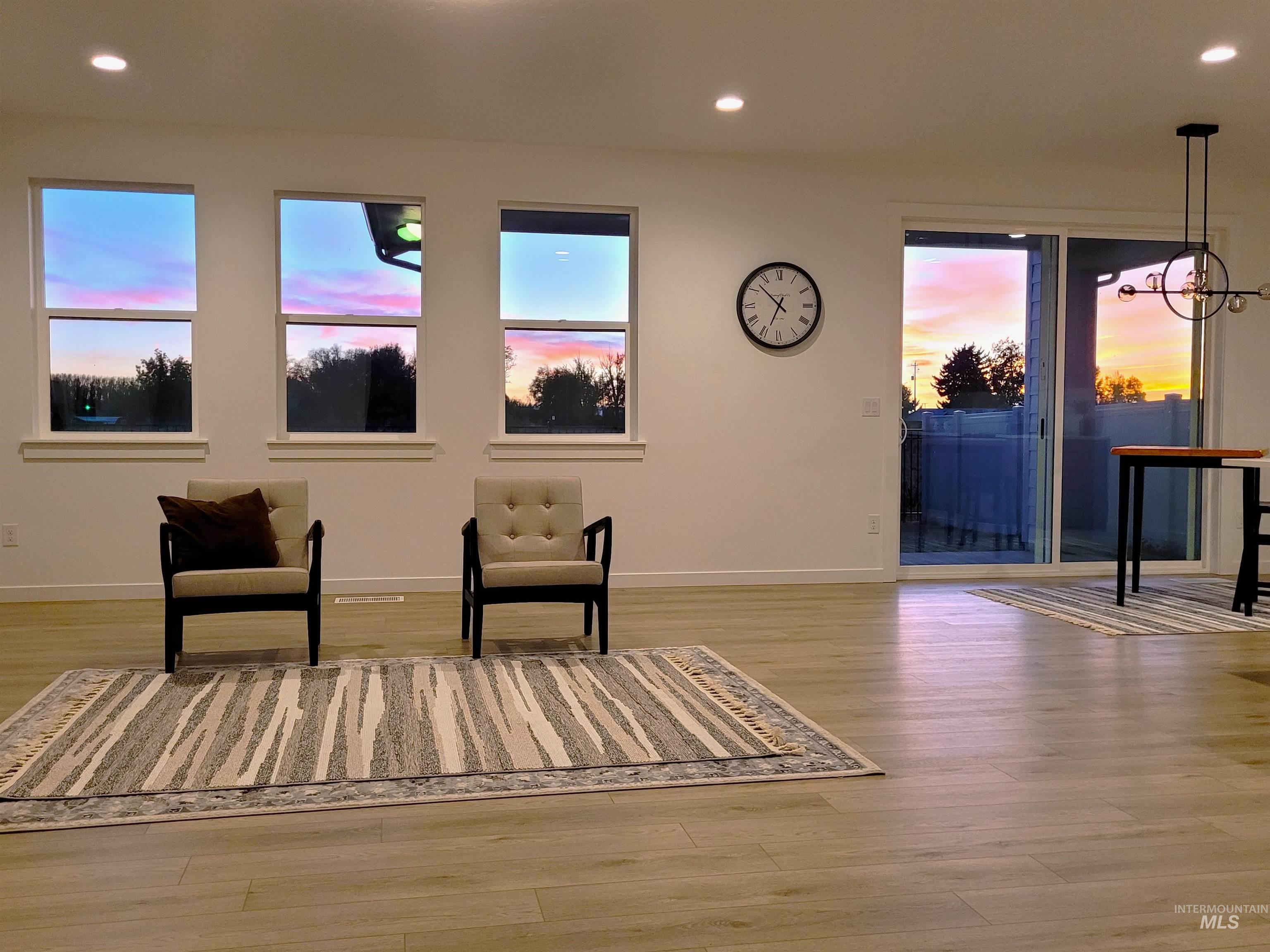 Living area featuring recessed lighting, light wood-style floors, a chandelier, and healthy amount of natural light