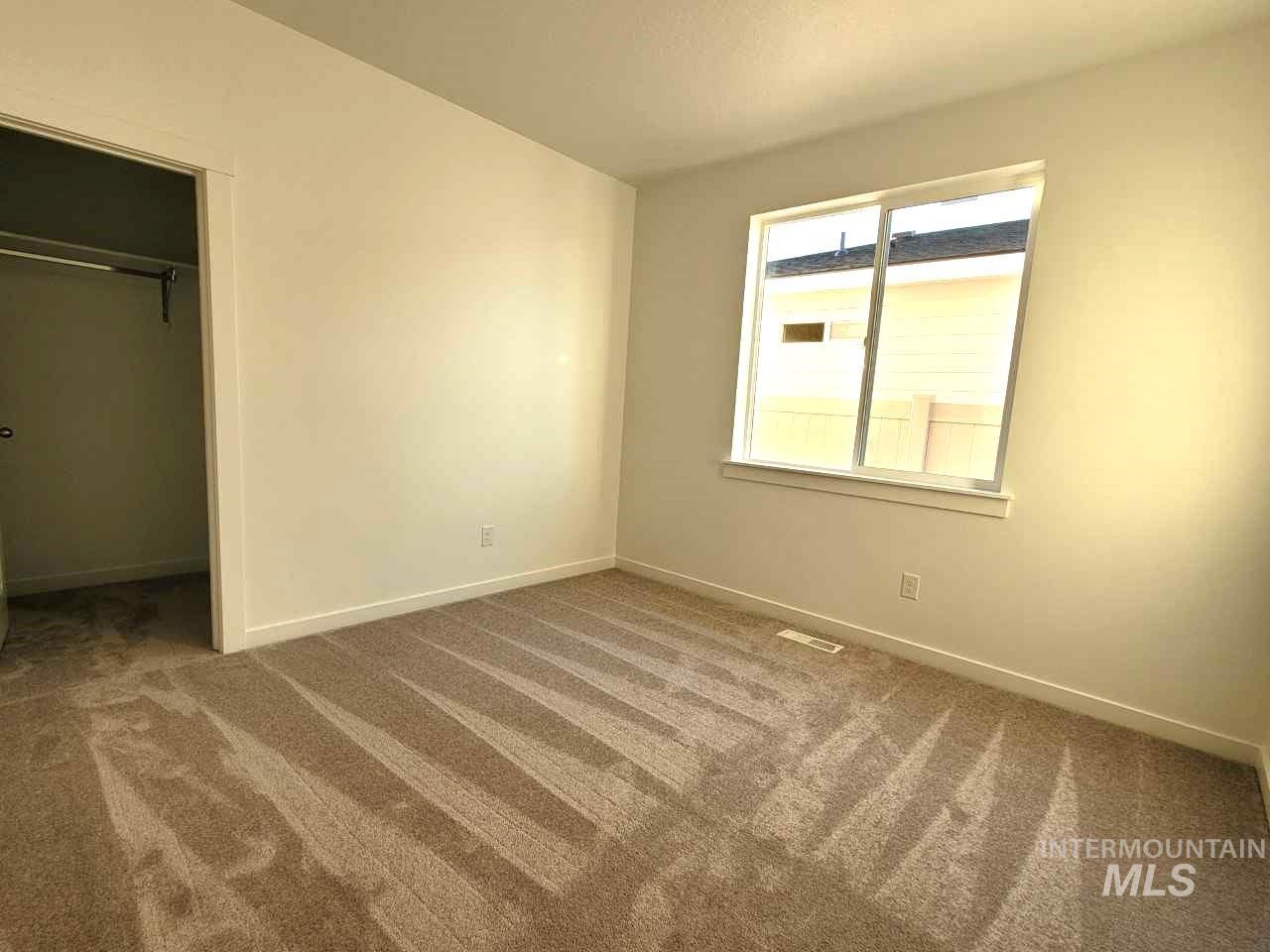 Unfurnished bedroom with light colored carpet and a closet