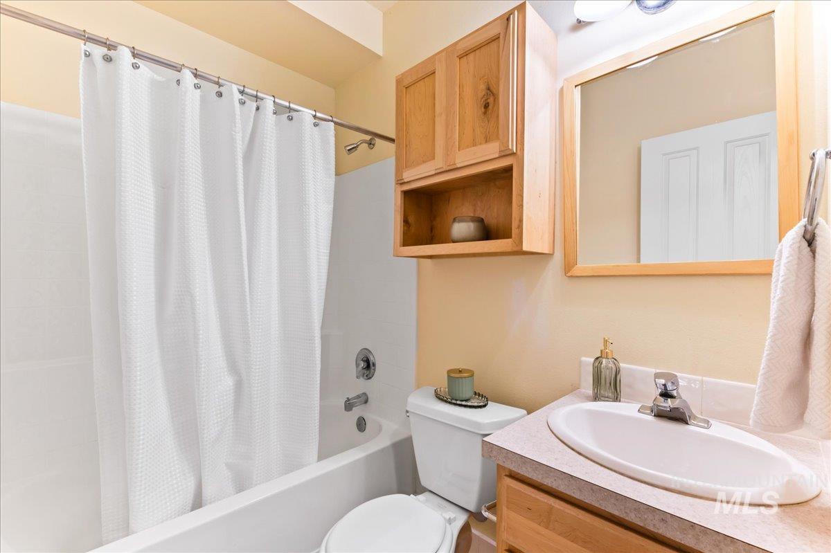 Bathroom with shower / bathtub combination with curtain and vanity