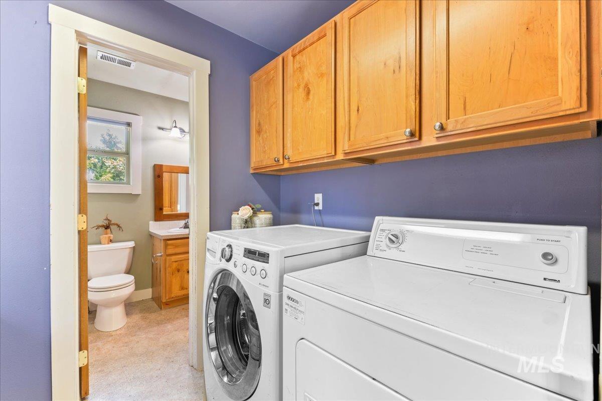 Washroom featuring washing machine and clothes dryer and cabinet space
