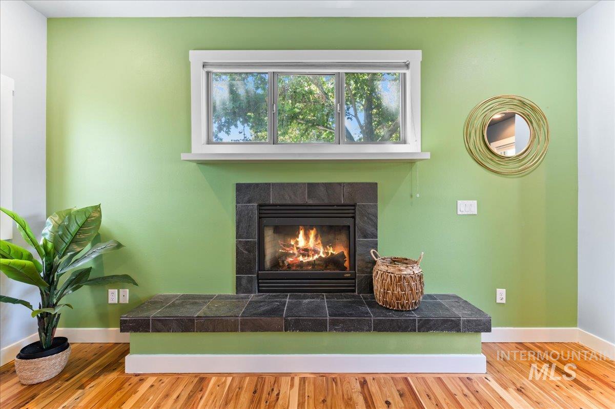 Detailed view of wood finished floors and a tiled fireplace