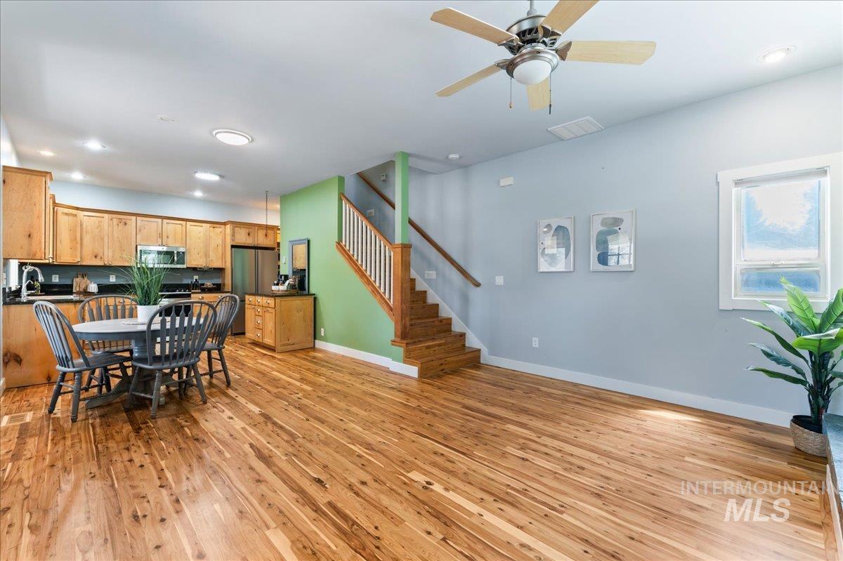 Dining area with light wood-style flooring, stairway, recessed lighting, and a ceiling fan