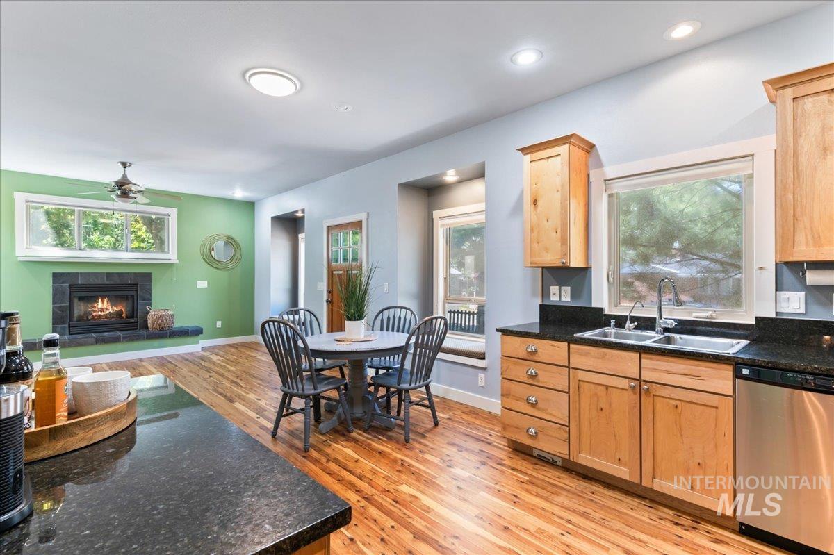 Kitchen with a tile fireplace, dishwasher, light wood-style floors, a ceiling fan, and recessed lighting