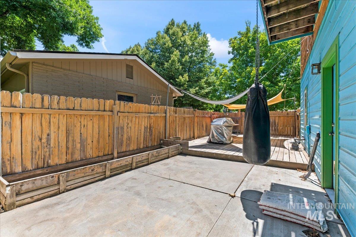 Fenced backyard with a patio, a deck, and area for grilling
