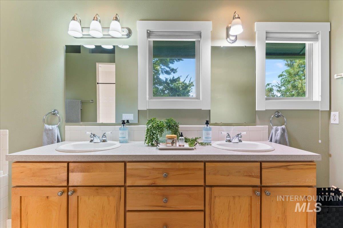 Full bathroom with double vanity and plenty of natural light