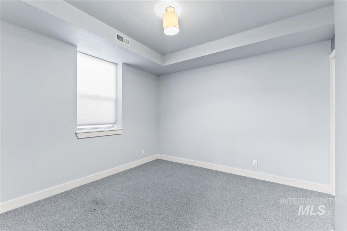 Carpeted spare room with baseboards