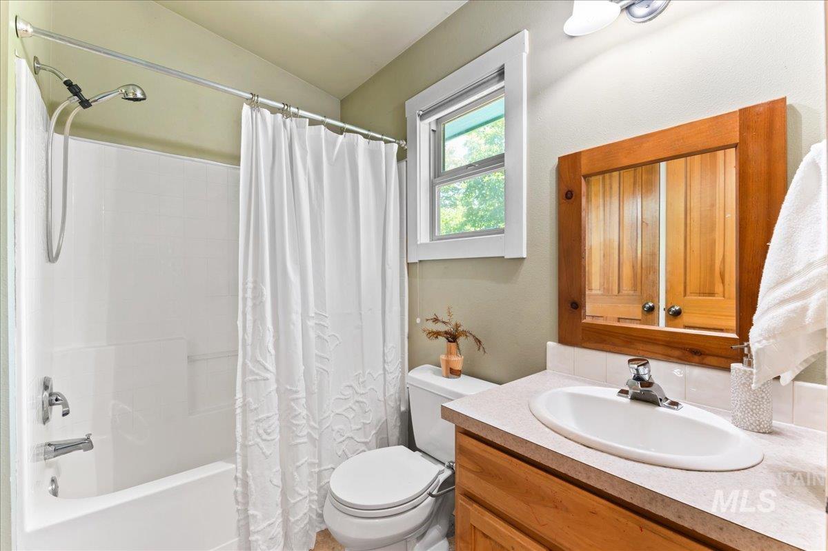 Full bathroom featuring vanity and shower / bath combination with curtain