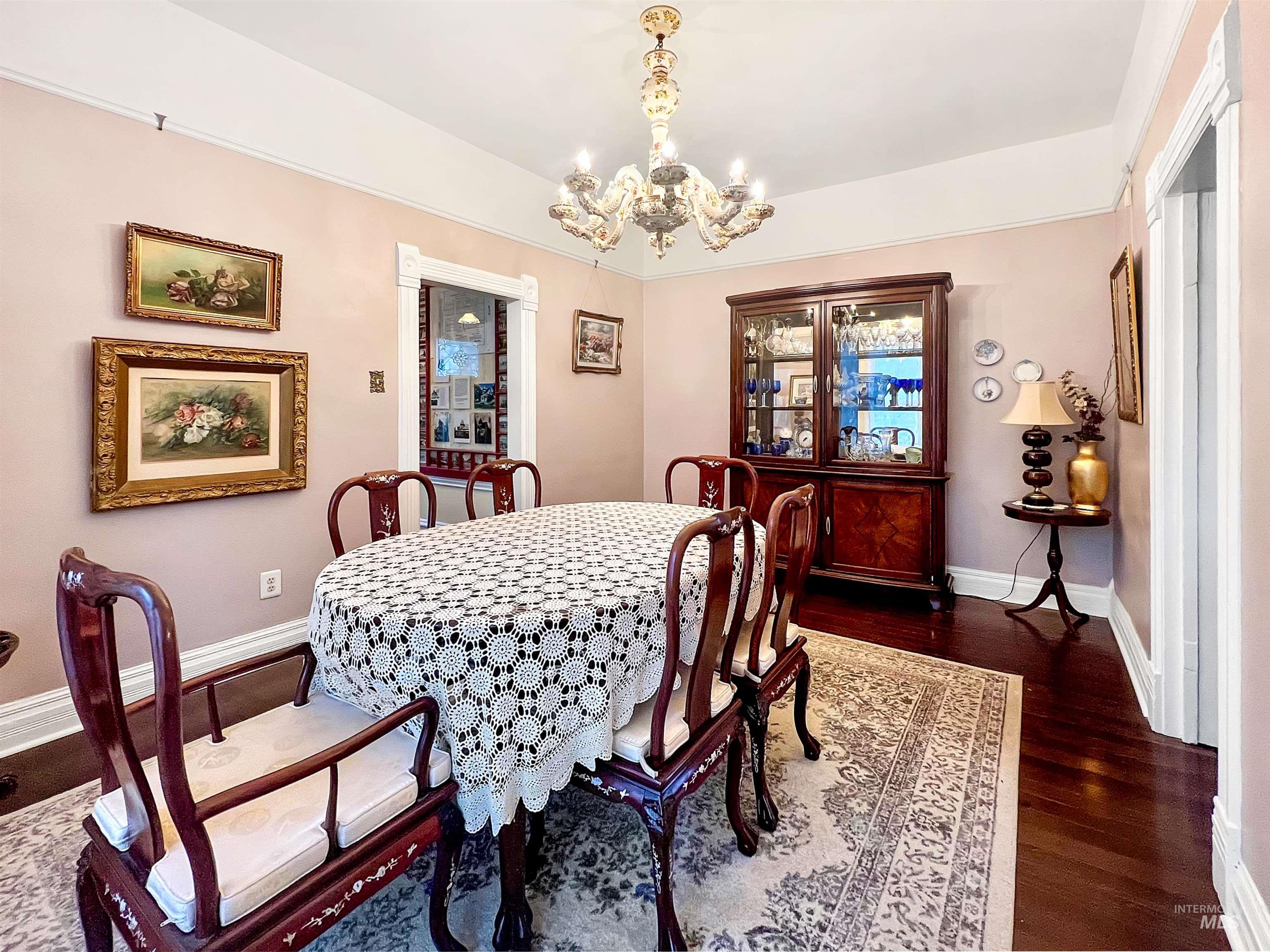 Dining room with amazing antique chandelier and dark wood finished floors