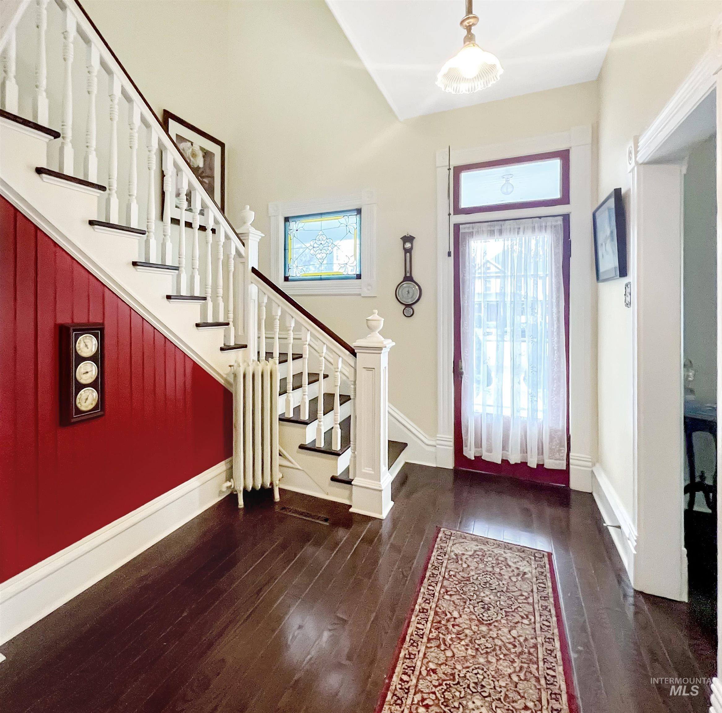 Foyer entrance featuring dark wood-style flooring and decorative radiator heating unit